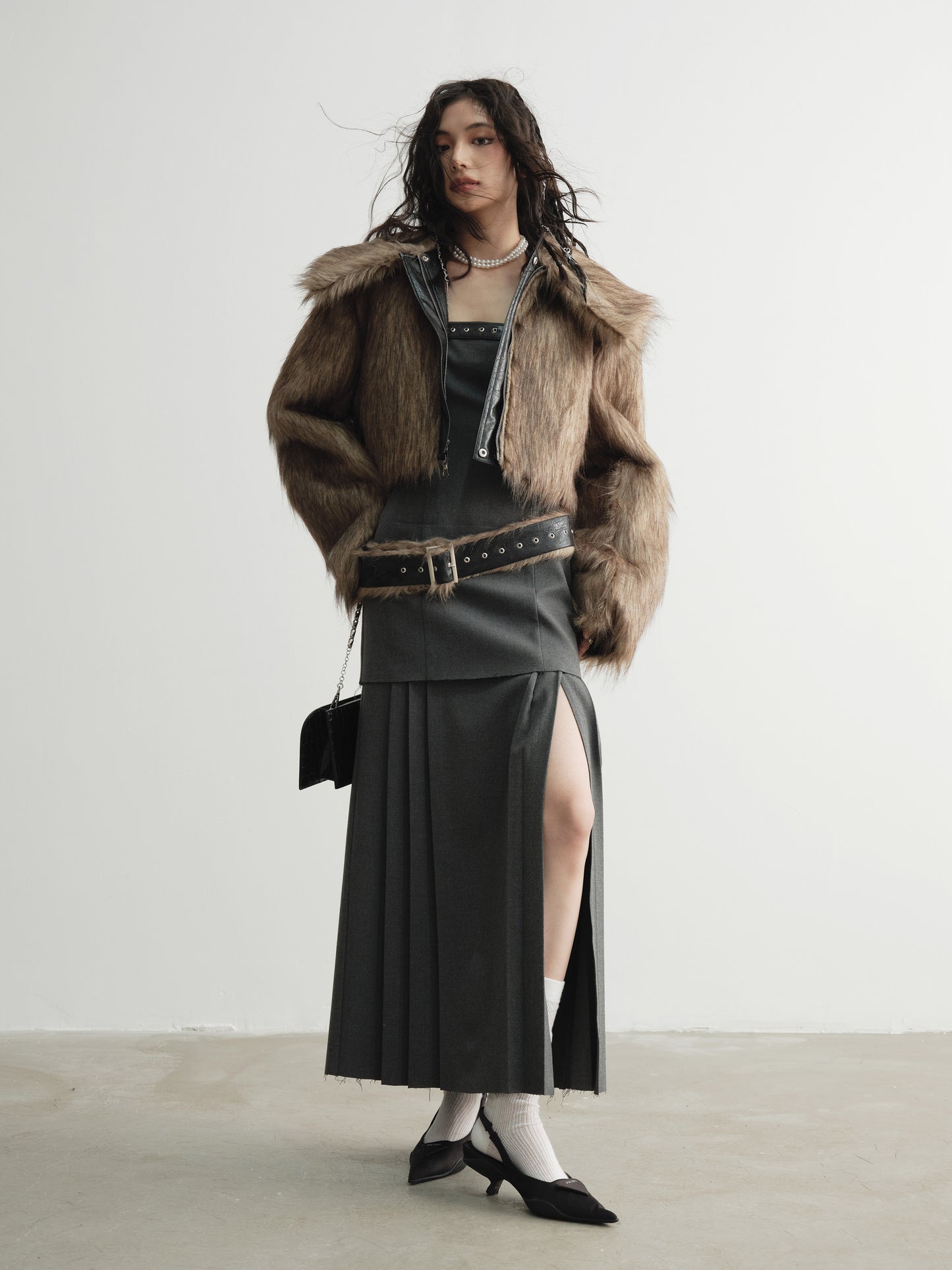 Model posing with Ara Ato's reversible Alix Jacket with the brown fur side on the exterior and black leather side on the interior.