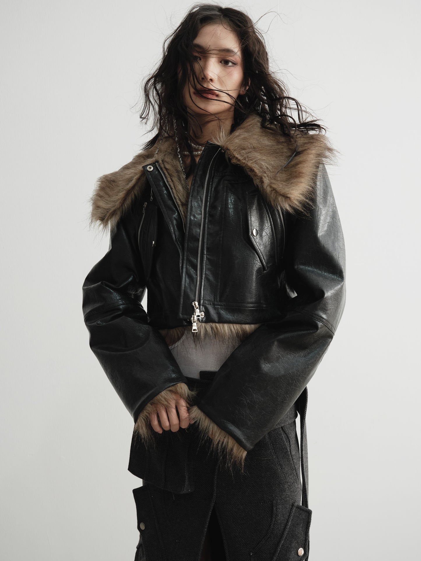 Close up view of model wearing Ara Ato's reversible Alix Jacket with the black leather side on the exterior and brown fur side on the interior.